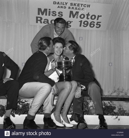 Graham Hill, Jim Clrk, et Jack Brabham font un câlin à Jackie Peterson  : MIss Motor Racing 1965...